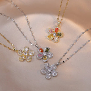 Three floral necklaces with gemstones on a beige background