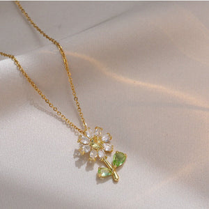 A set of jewelry including a flower pendant necklace and earrings, with white and green stones set in gold-plated titanium steel.