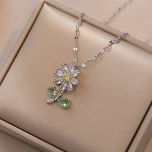 A set of jewelry including a flower pendant necklace and earrings, with white and green stones set in gold-plated titanium steel.