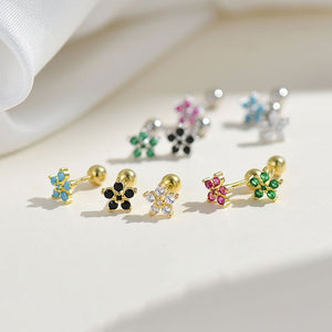 Gold earrings with gemstones on a light fabric background