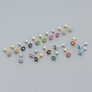 Collection of colorful belly button rings on a gray background