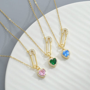 Gold necklaces with colorful heart pendants on a white surface