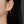 Close-up of a person wearing turquoise earrings with a blurred background