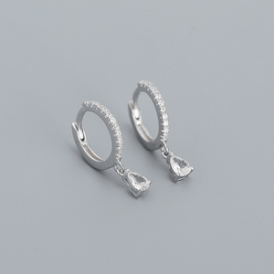Silver hoop earrings with teardrop-shaped gemstones on a gray background
