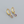 Gold hoop earrings with purple teardrop stones on a gray background