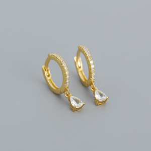 Gold hoop earrings with teardrop-shaped gemstones on a gray background
