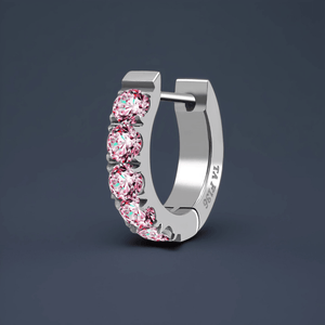 Silver hoop earring with pink gemstones on a dark background