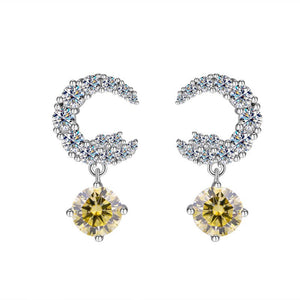 A pair of silver drop stud earrings with central moissanite gemstone surrounded by smaller clear crystals on a white background.