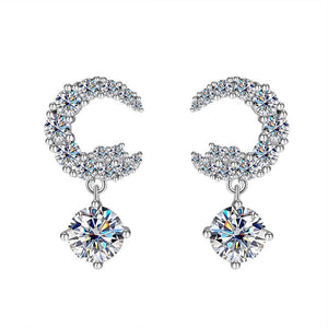 A pair of silver drop stud earrings with central moissanite gemstone surrounded by smaller clear crystals on a white background.