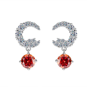 A pair of silver drop stud earrings with central moissanite gemstone surrounded by smaller clear crystals on a white background.