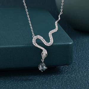 Silver snake-shaped necklace with a pendant on a green box