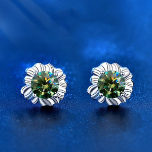Silver earrings with green gemstones on a blue background