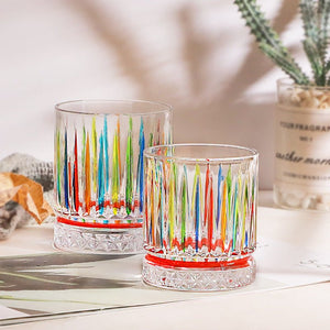 Two colorful glass tumblers on a light surface with a blurred background
