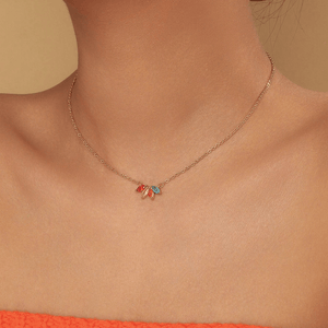 Necklace with colorful pendant worn by a person against a neutral background