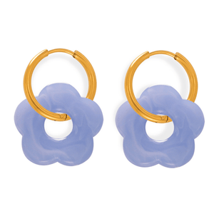 Pair of earrings with gold loops and purple flower-like ends on a white background