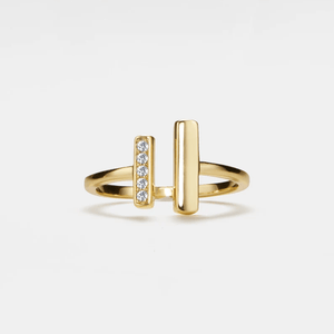 Gold ring with horizontal and vertical bars on a light gray background