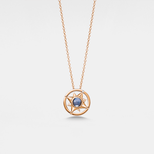 Rose gold necklace with a circular pendant featuring a blue gemstone on a light gray background
