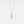 Gold necklace with a crescent moon pendant on a light gray background