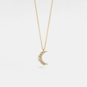 Gold necklace with a crescent moon pendant on a light gray background