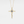 Gold cross necklace with a blue gemstone on a light gray background