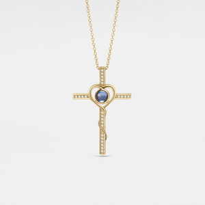 Gold cross necklace with a blue gemstone on a light gray background