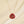 Necklace with a red teardrop pendant on a beige background