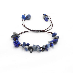 A collection of braided bracelets with various colored crystal stones, displayed on a white surface.