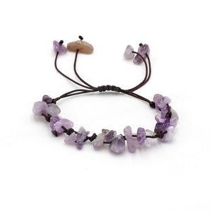 A collection of braided bracelets with various colored crystal stones, displayed on a white surface.