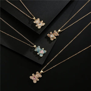 Gold necklaces with floral pendants on a black background