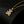 Gold necklace with a teddy bear pendant on a black background