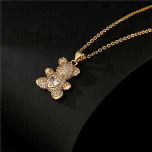 Gold necklace with a teddy bear pendant on a black background