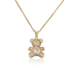 Gold teddy bear pendant necklace with clear stones on a white background