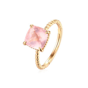 Gold ring with a pink gemstone on a white background