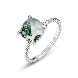 Silver ring with a green gemstone on a white background