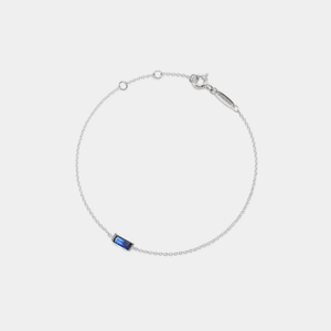 A gold-plated sterling silver bracelet with a single green birthstone charm, on an adjustable chain.