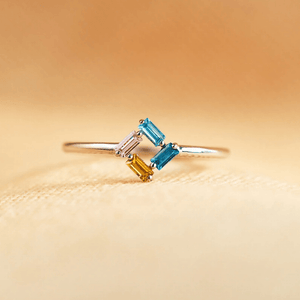 Ring with multicolored gemstones on a beige background