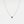 Gold necklace with a red gemstone on a white background
