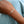 Bracelet with colorful beads on a wrist against a light blue fabric background