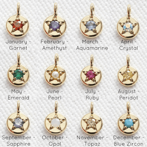 Gold star-shaped birthstone charms with corresponding months and gemstones on a white background