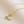 Gold necklace with two round pendants on a beige fabric background