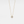 Gold necklace with a small round pendant on a light gray background
