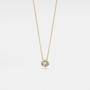 Gold necklace with a small round pendant on a light gray background