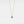 Gold necklace with a blue gemstone pendant on a light gray background