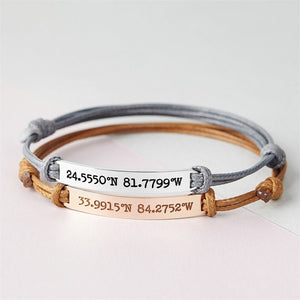 Stack of three bracelets with engraved coordinates on a light background