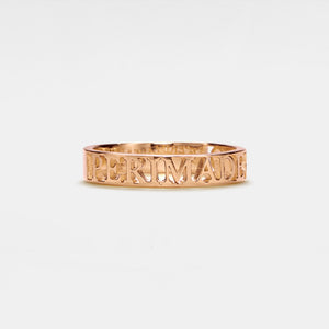 A gold-plated sterling silver band ring with engraved text on it.