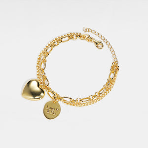 Gold bracelet with heart locket and 'Love P & Co' tag on a white background