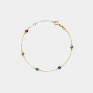 Gold bracelet with colorful gemstones on a white background