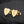 Gold heart-shaped earrings with 'A' engraving on a dark background