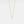 Gold necklace with a 'A' pendant on a light gray background