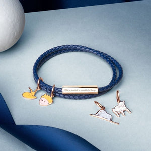 Blue braided bracelet with charms on a light blue background